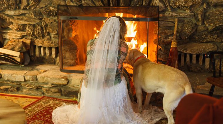 Bride and her dog in front of the fireplace