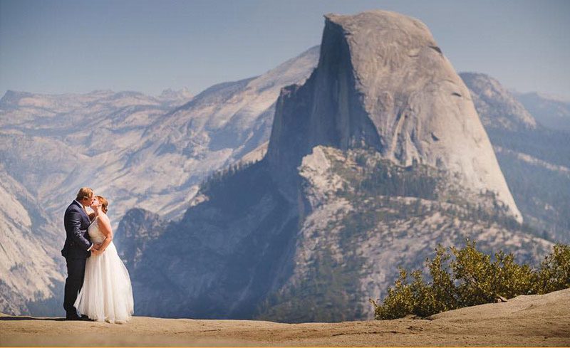 Bride and Groom at Glacier Point with Half Dome behind.