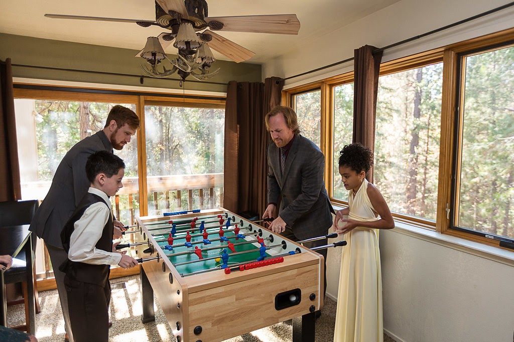 Kids and adults playing foozeball in a vacation rental cabin