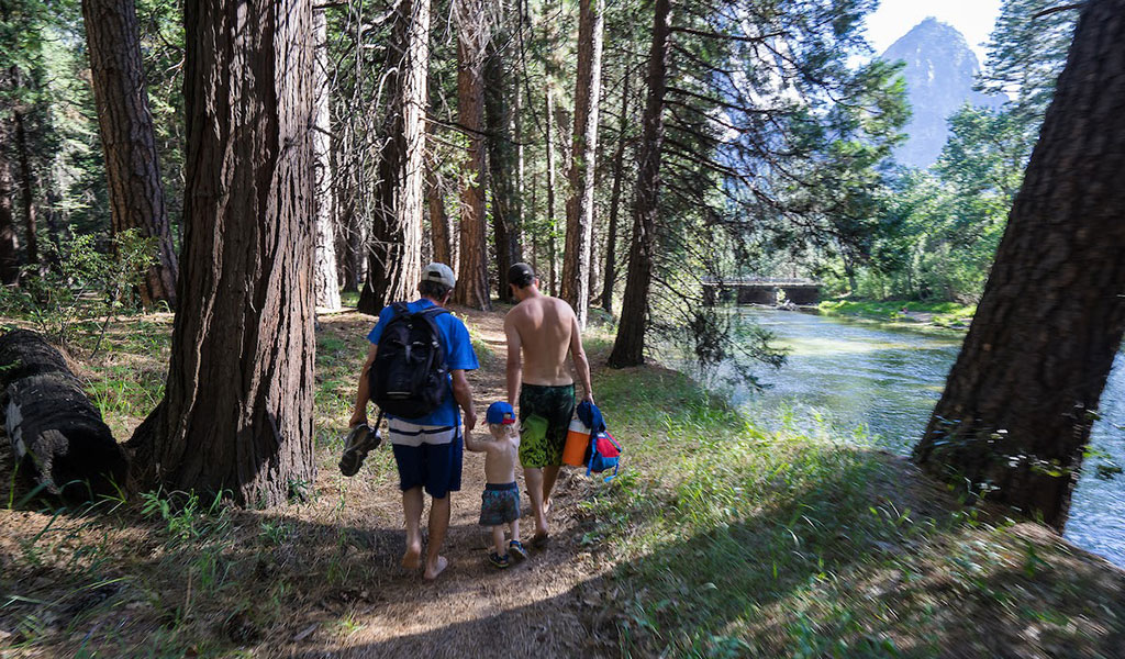 Family walking next to the Merced River