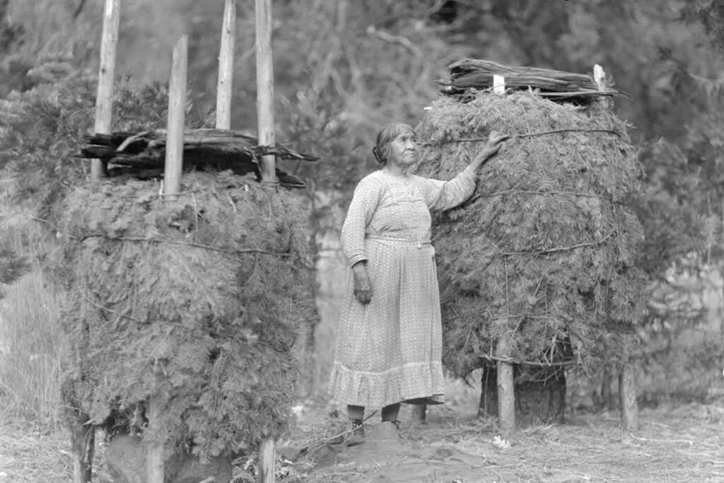 woman standing with acorn granaries called chuckas