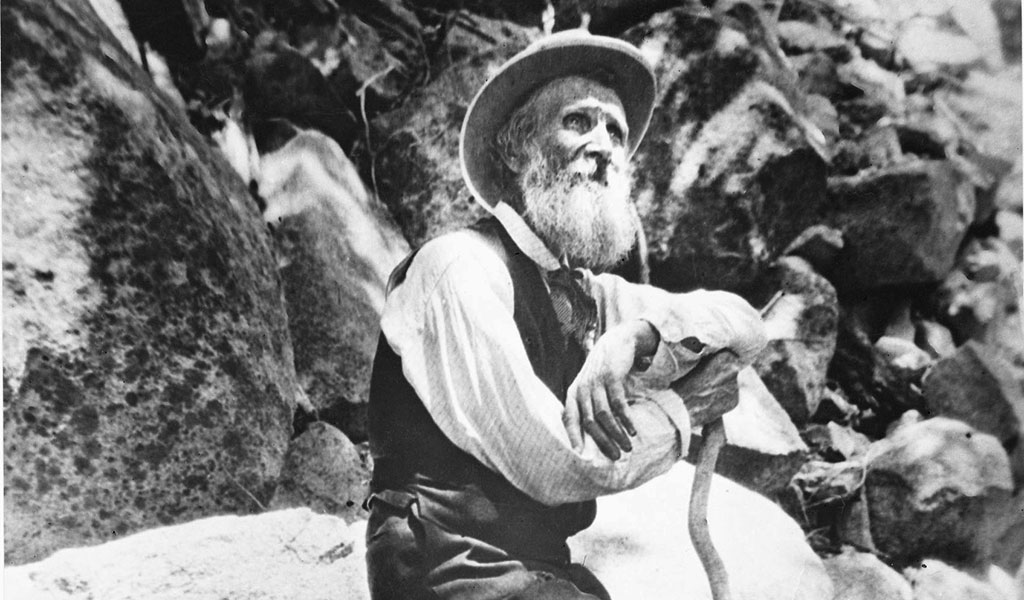 John Muir seated on a granite rock